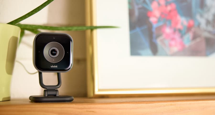 Vivint indoor camera installed on a mantel beside a framed picture